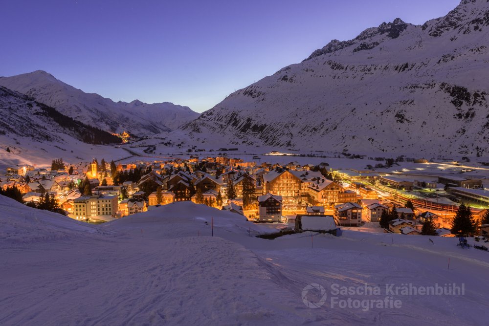 Andermatt im Schnee - Nachmittags lief ich auf den Oberalppass mit den Schneeschuhen los und erreichte zur Blauen Stunde das Dorf Andermatt. (Sascha Krähenbühl Fotografie) - Schalgwörter: Alpen ,Andermatt ,Berge ,blickheimat ,Fotografie ,LakeLucerneRegion ,Landschaft ,Landschaftsfotograf ,Landschaftsfotografie ,Natur ,NikonSwitzerland ,Schnee ,Schweiz ,Sonnenuntergang ,Uri ,VerliebtInDieSchweiz ,VisitUri ,Winter ,Zentralschweiz